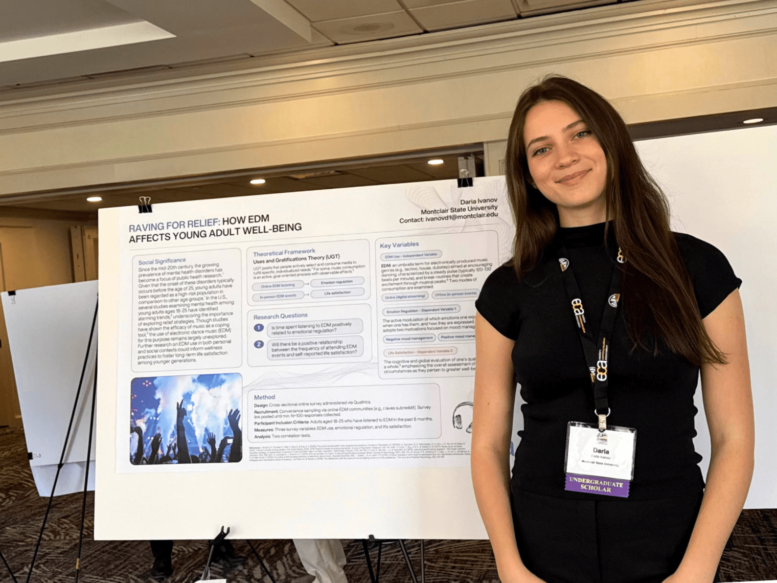 Student stands in front of her research project on display.