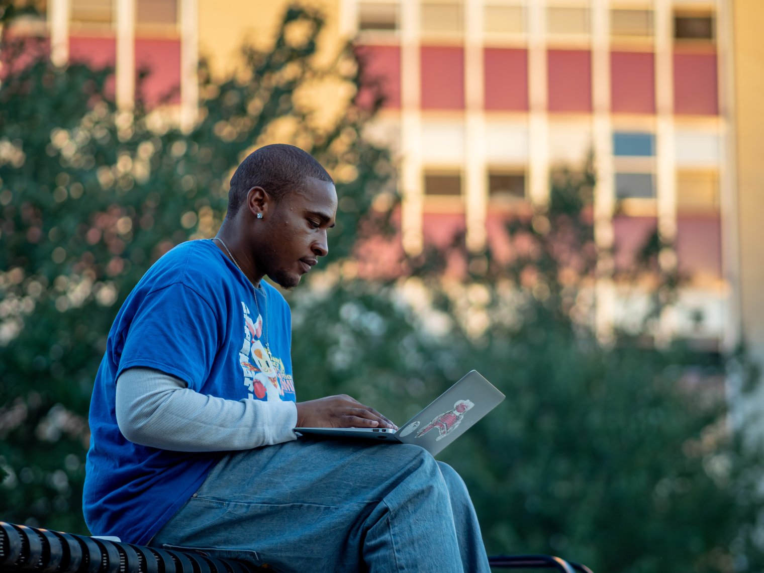 Student working on laptop outside