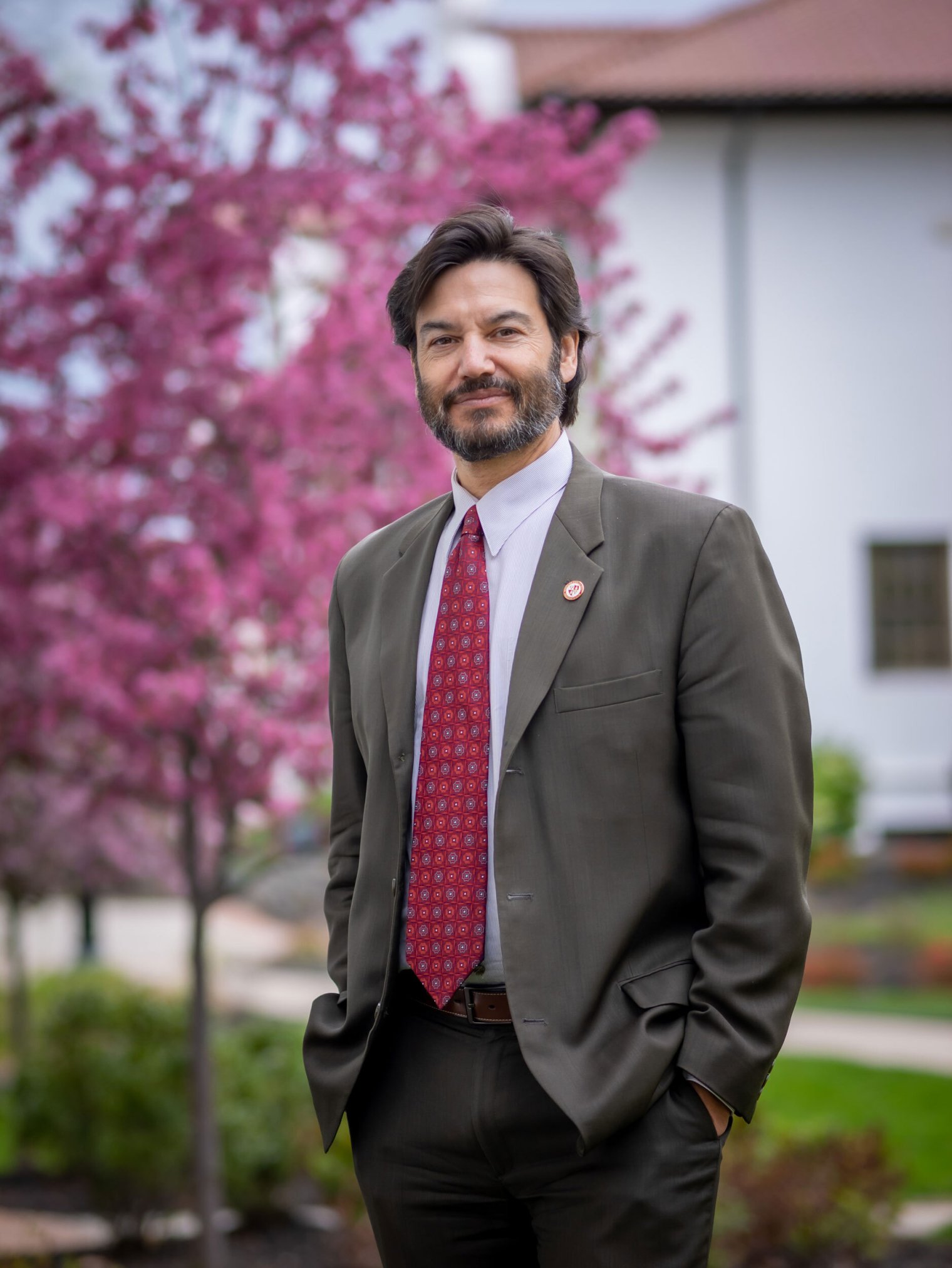 President Jonathan GS Koppell standing in front of pink blooming tree in spring