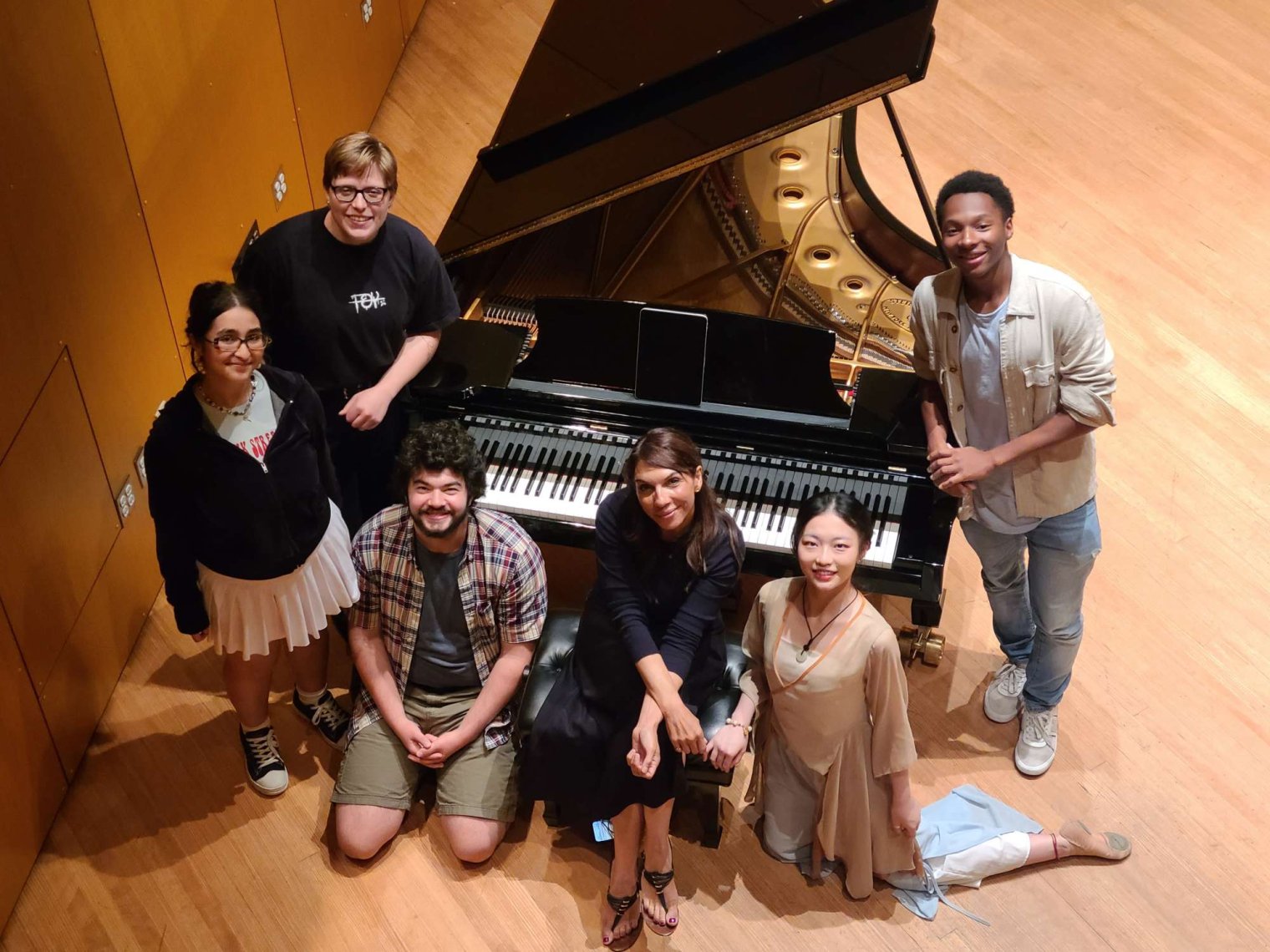 Laura Downes with Artist Vision Students on stage with a piano