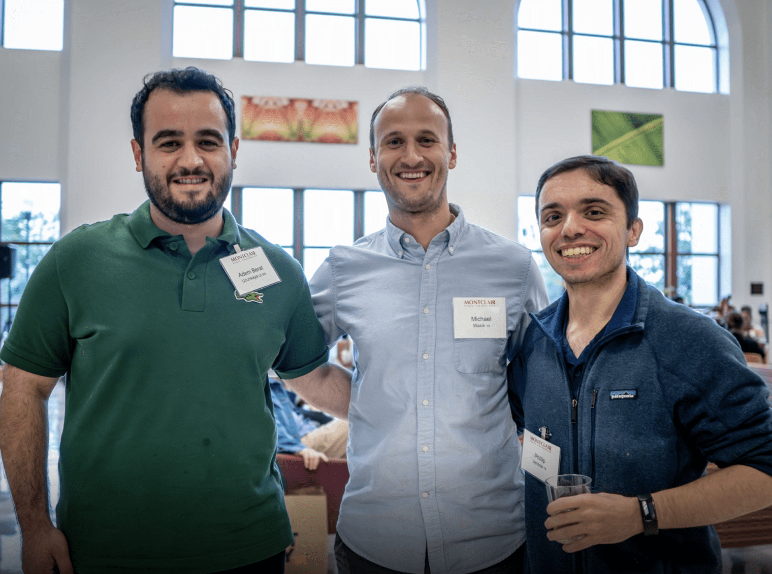 three alumni standing together at the red hawk social