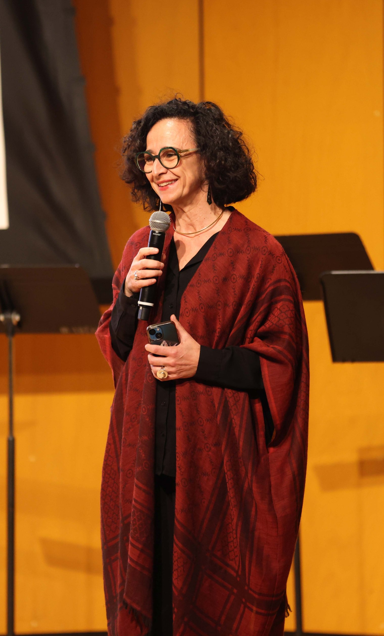 College professor speaking on stage with a microphone