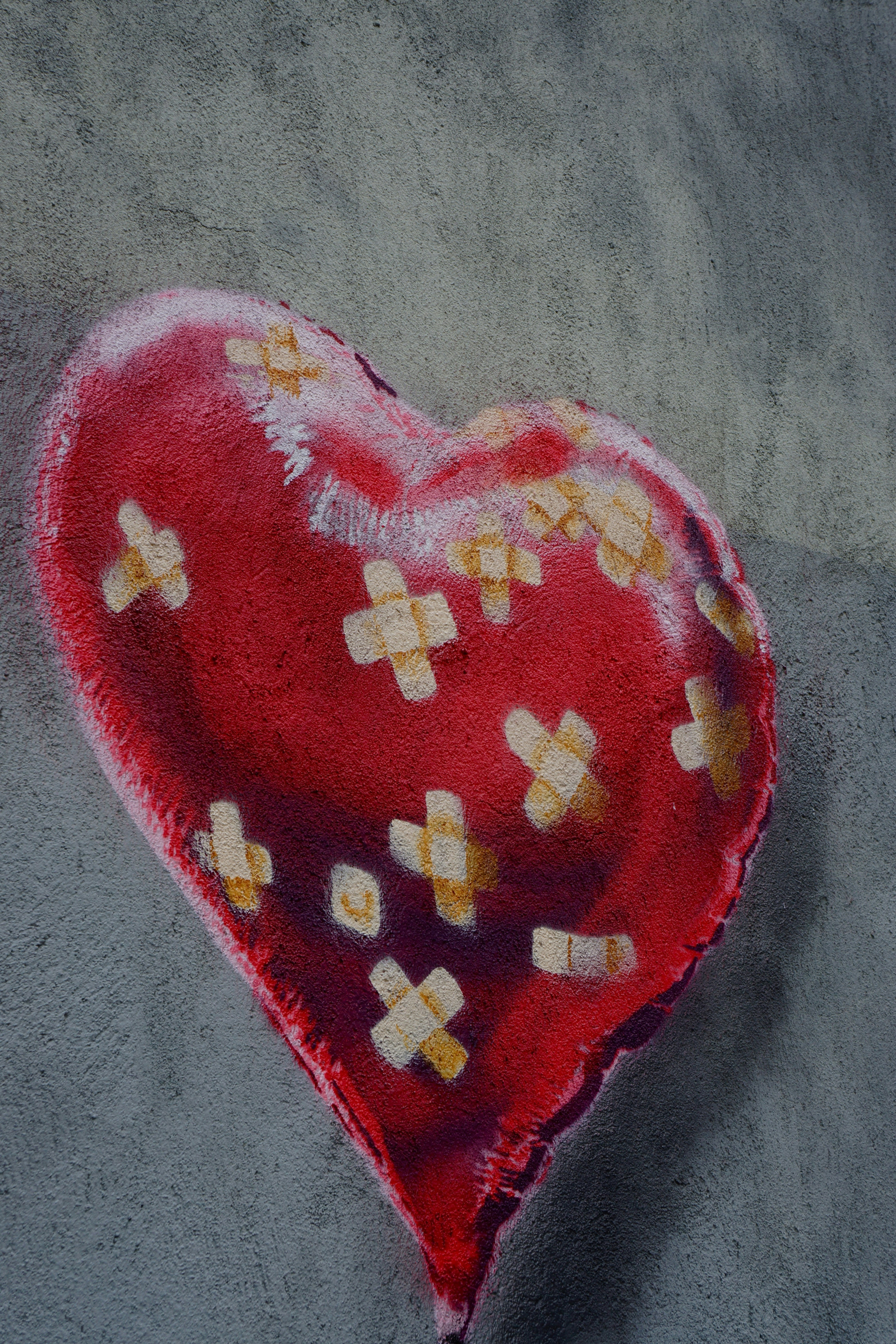 A red heart-shaped balloon with bandages