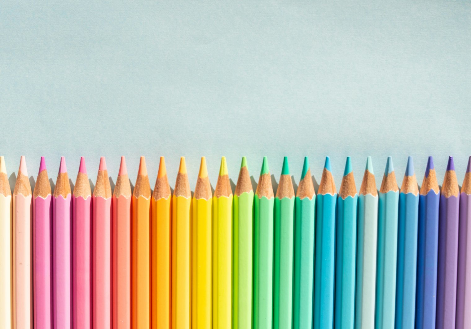 An array of colored pencils on gray surface
