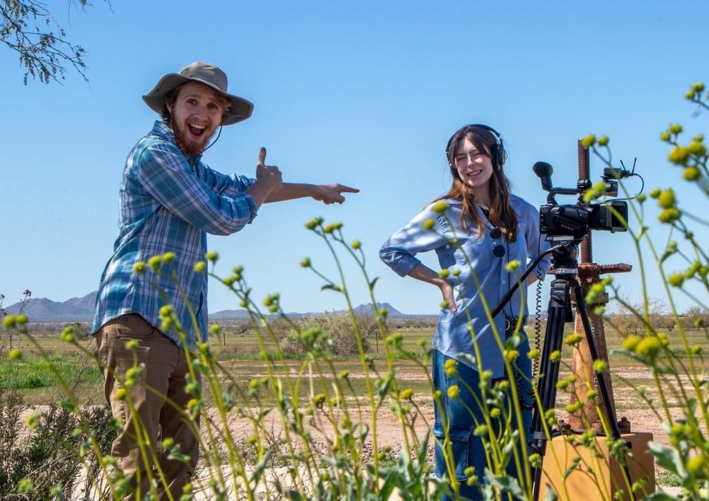 Two students filming outside.
