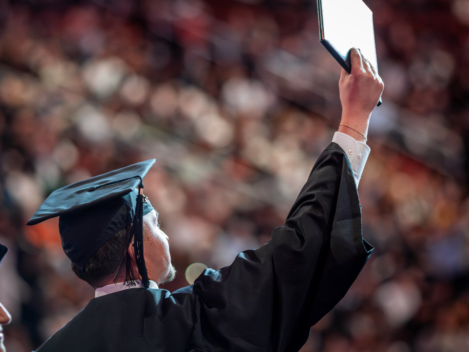 Graduate raises diploma to crowd