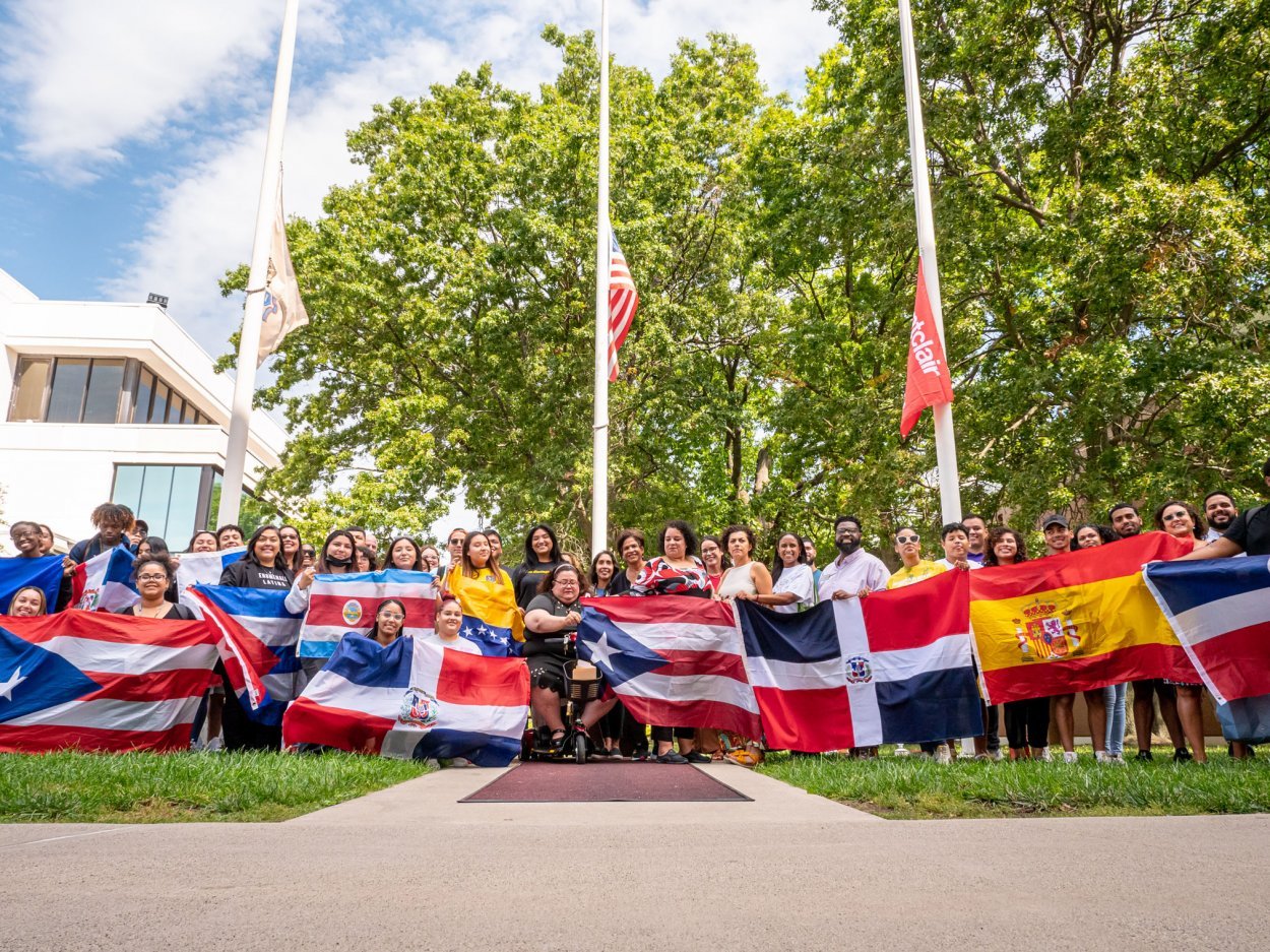 Group of HLAN alumni and students with flags