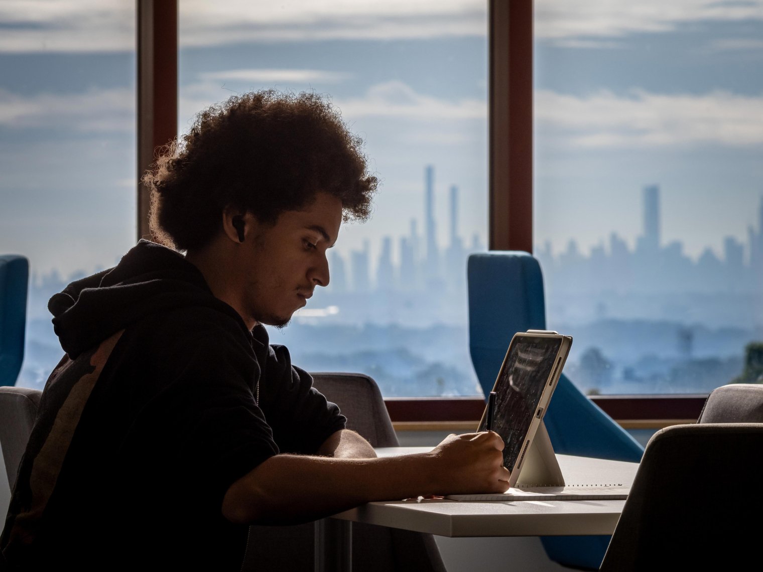 Student working online with NYC skyline in background