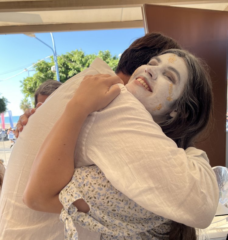 A woman in an ancient Greek costume hugs someone