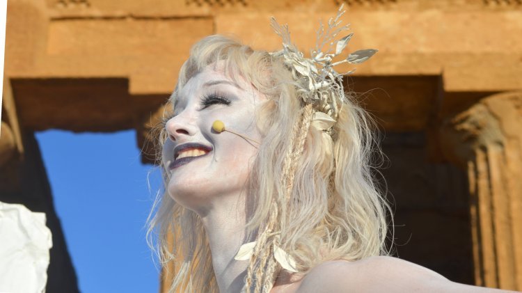 Headshot of a woman on stage wearing an ancient Greek costume