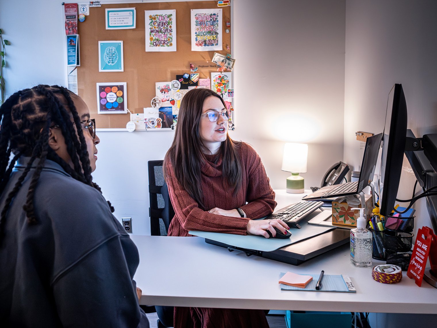 photo of career advisor Macayla Mack with a student in her office for an appointment, they are looking at a computer