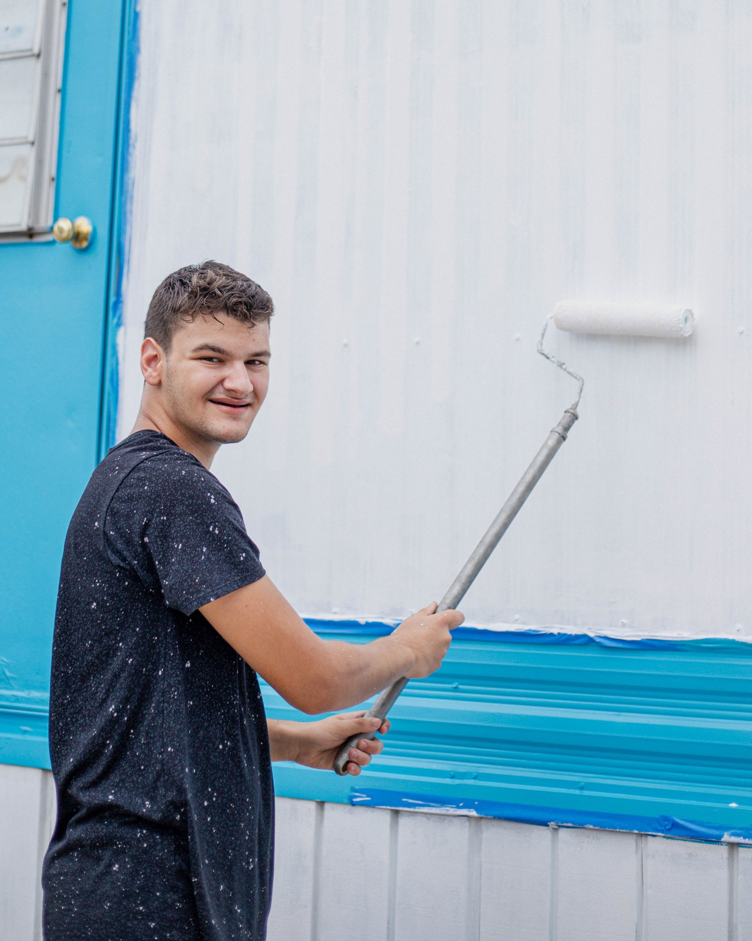Photo of Gregory Vitali painting trailer during bonner summer orientaiton 