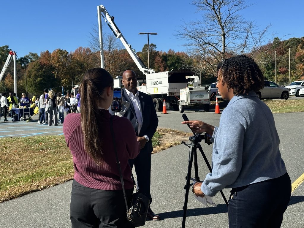 Student interviews someone while second crew member assists.