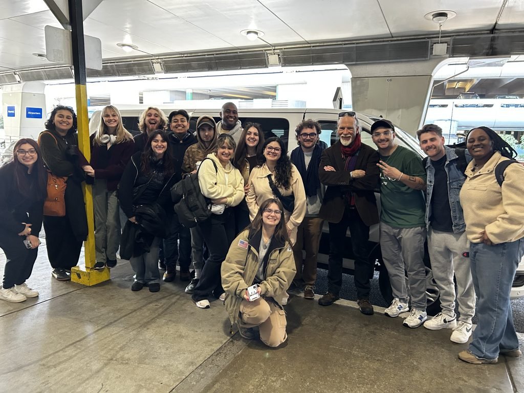 Students pose for a group photo at airport.