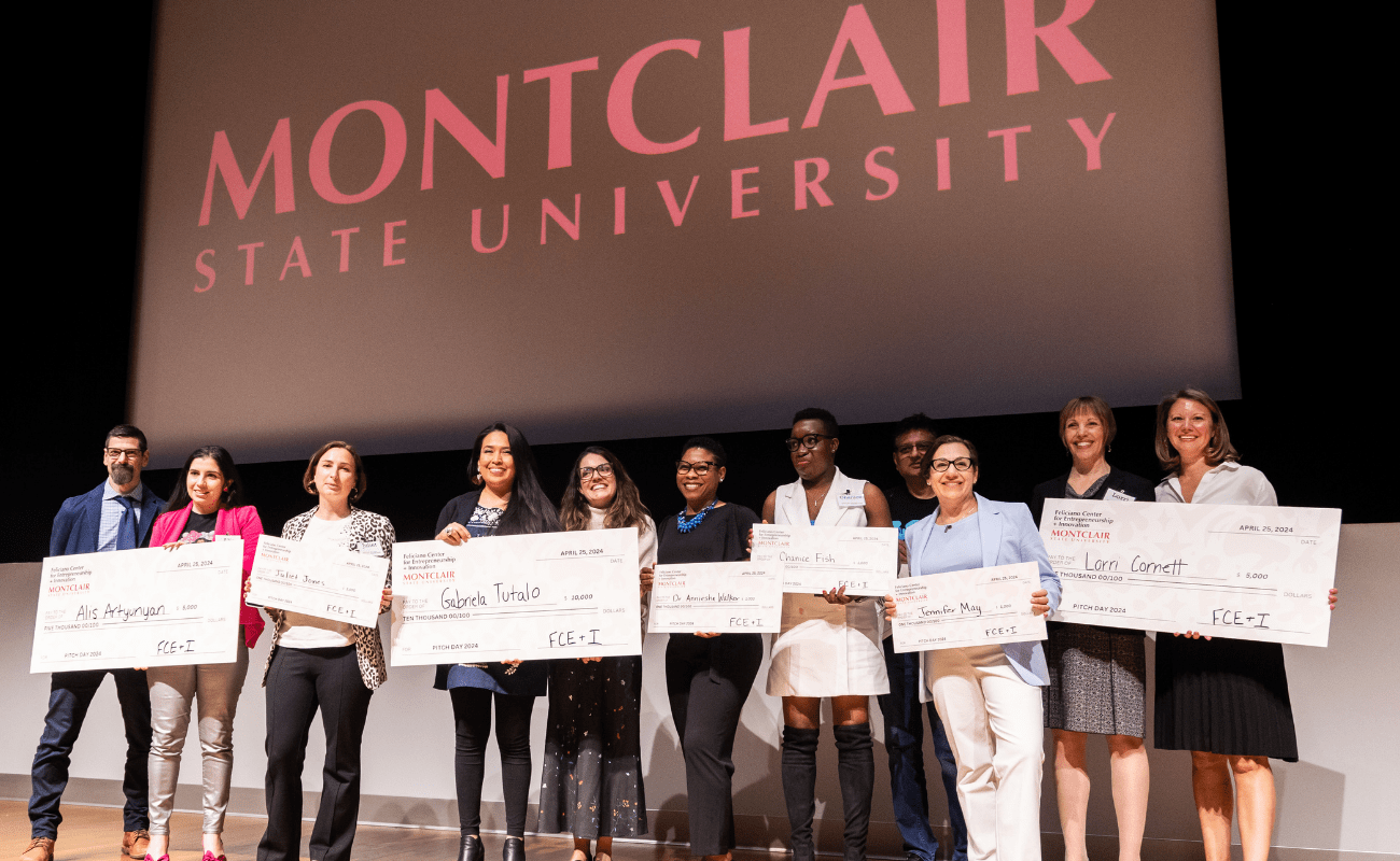 Finalists at Pitch Day 2024 holding checks on a stage