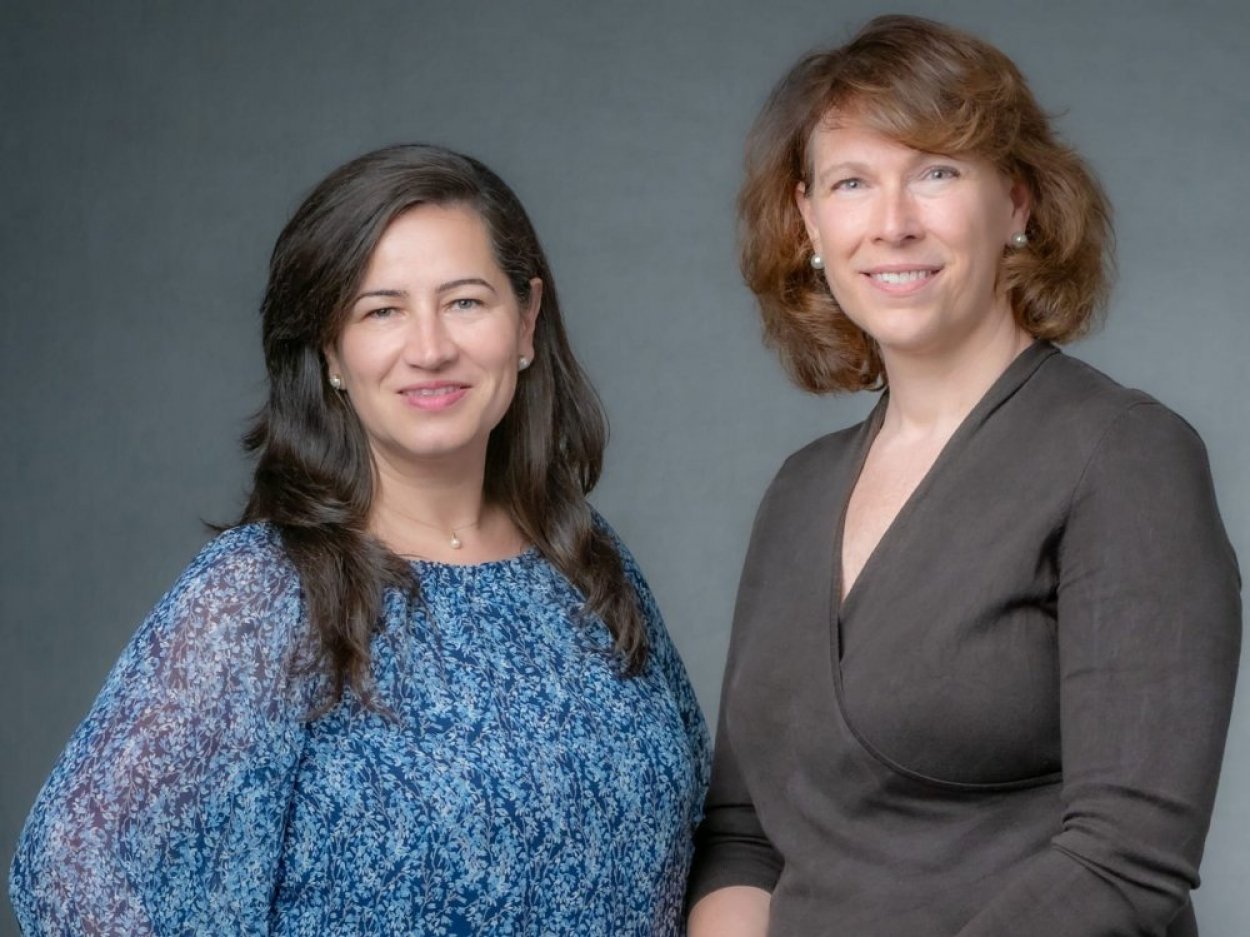 Two people in professional clothes pose in a a photo studio