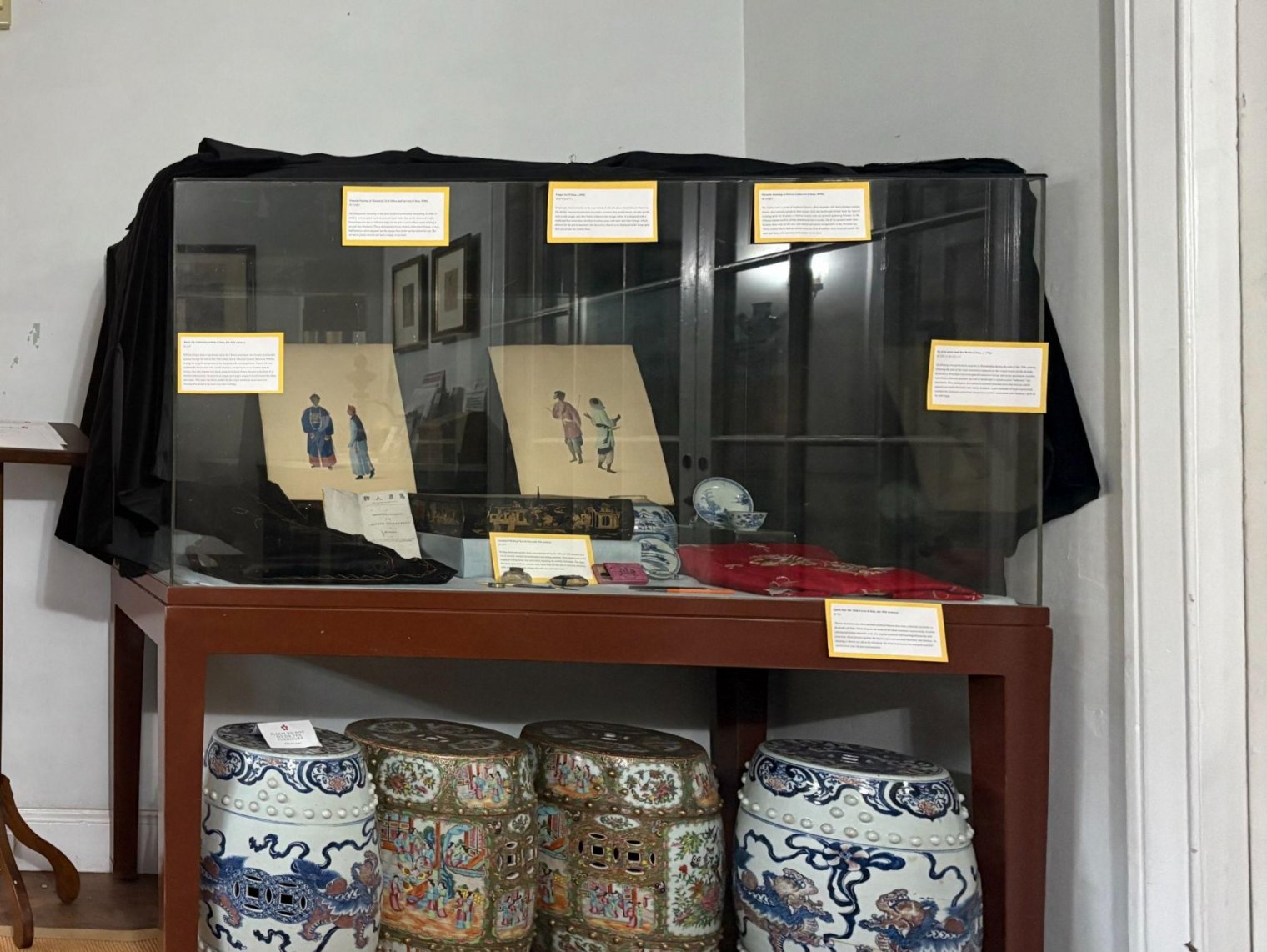 A display case of Chinese objects including paper and porcelain objects