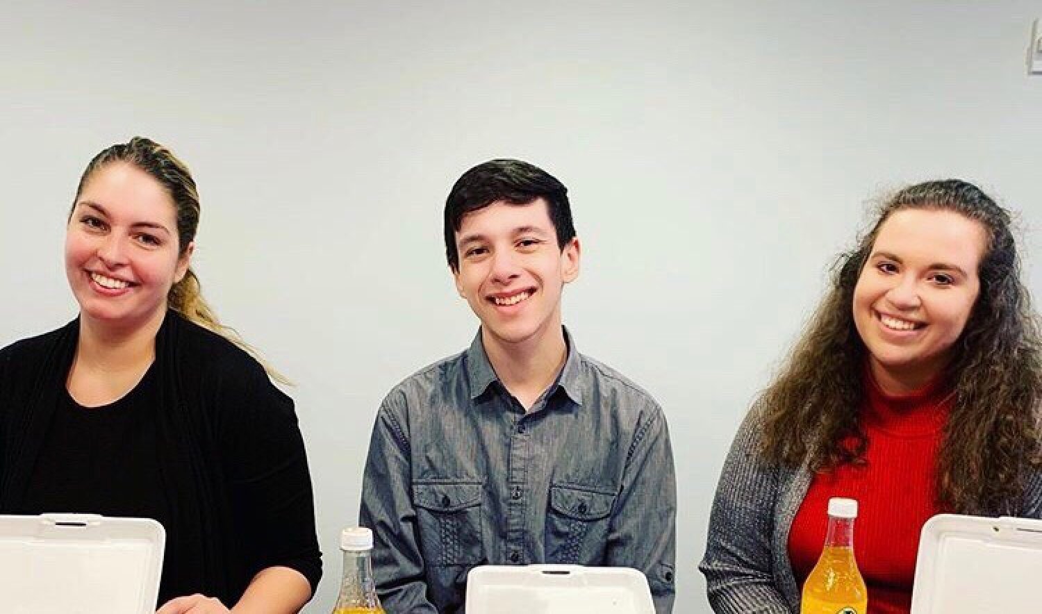 Three college students pose in a conference room