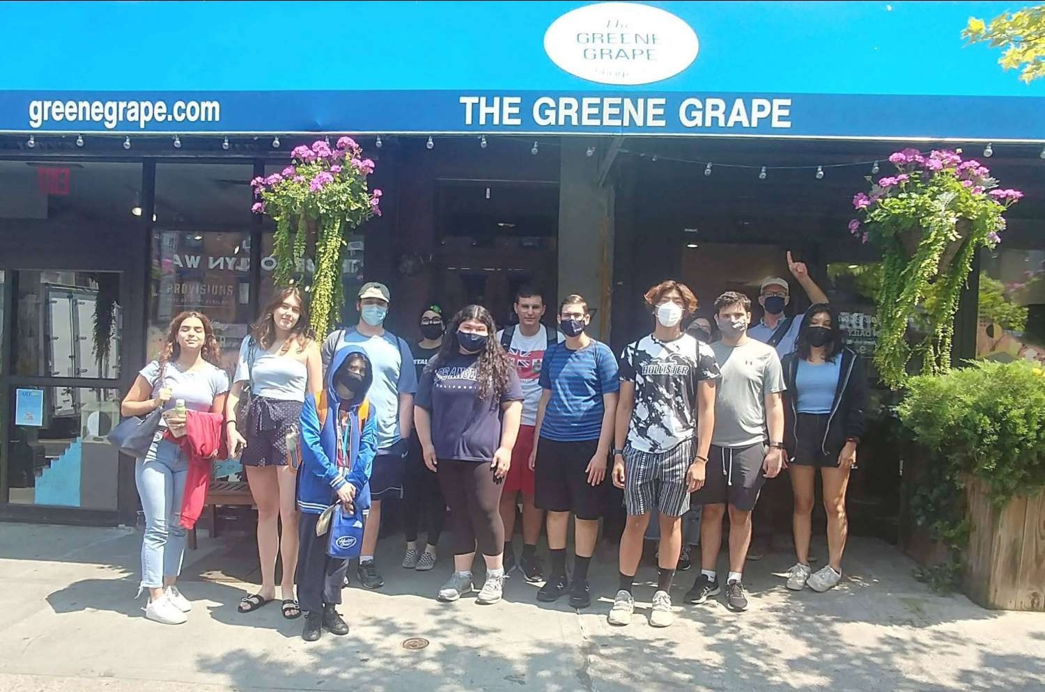 A group of college students posing in front of the Greene Grape