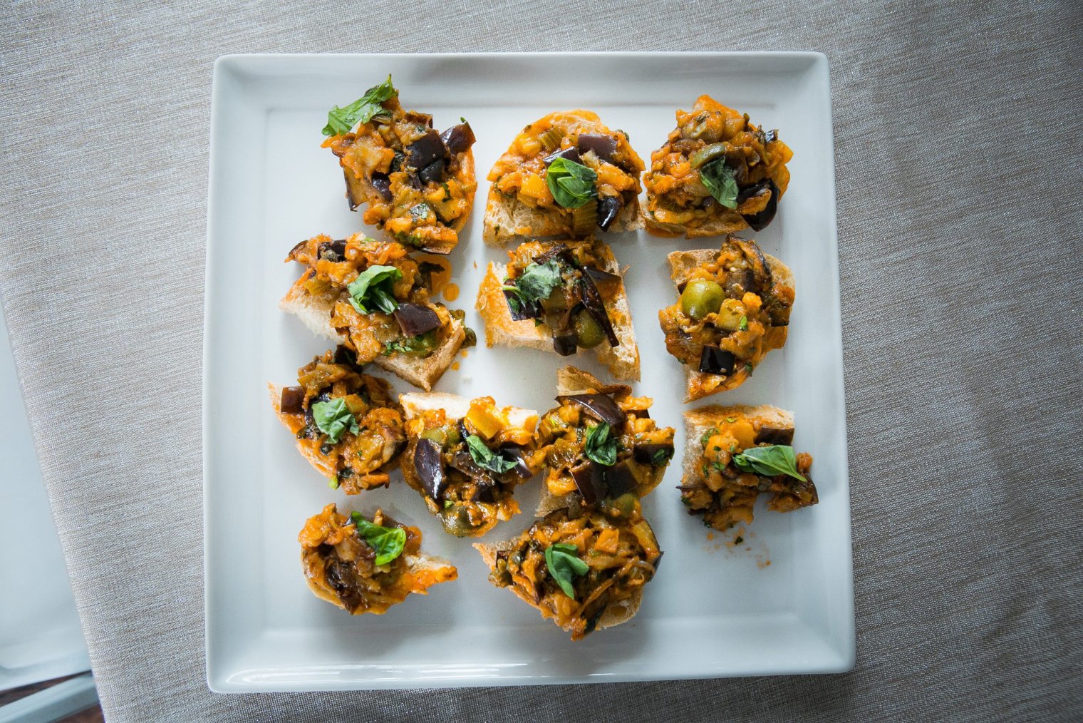 A square plate loaded with  appetizer bites