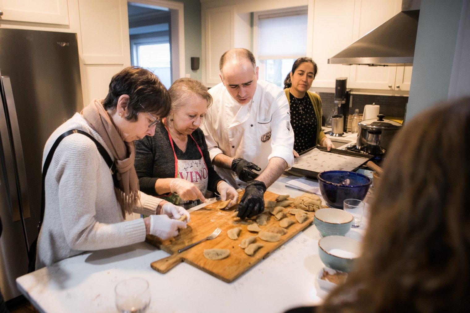 Three people prepare food in a kitchen