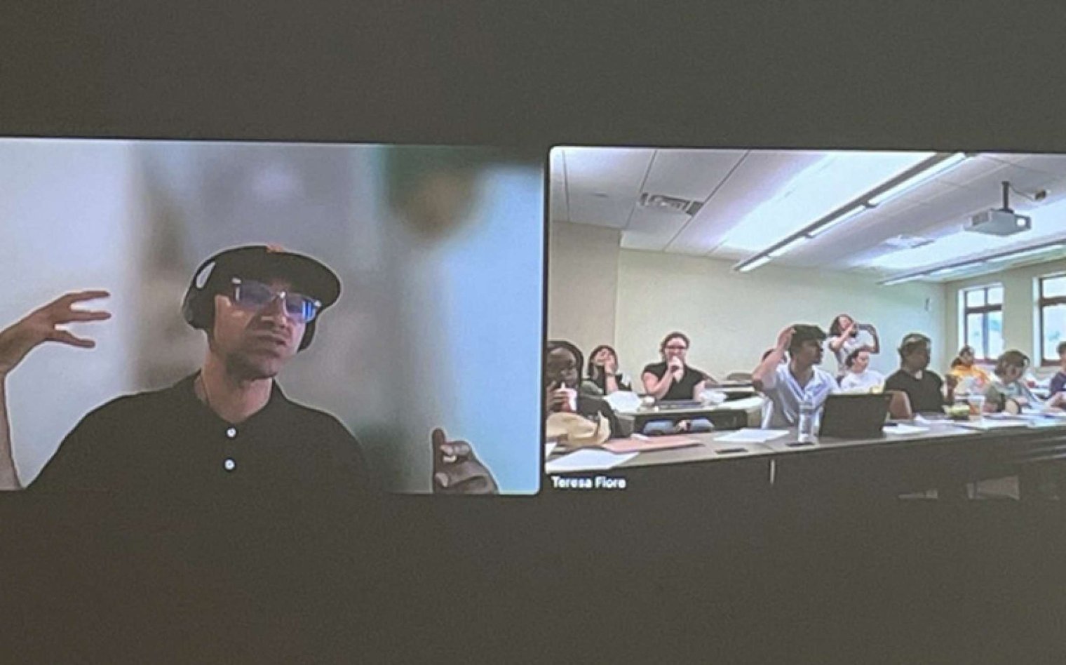 A Zoom call is displayed on a projector screen