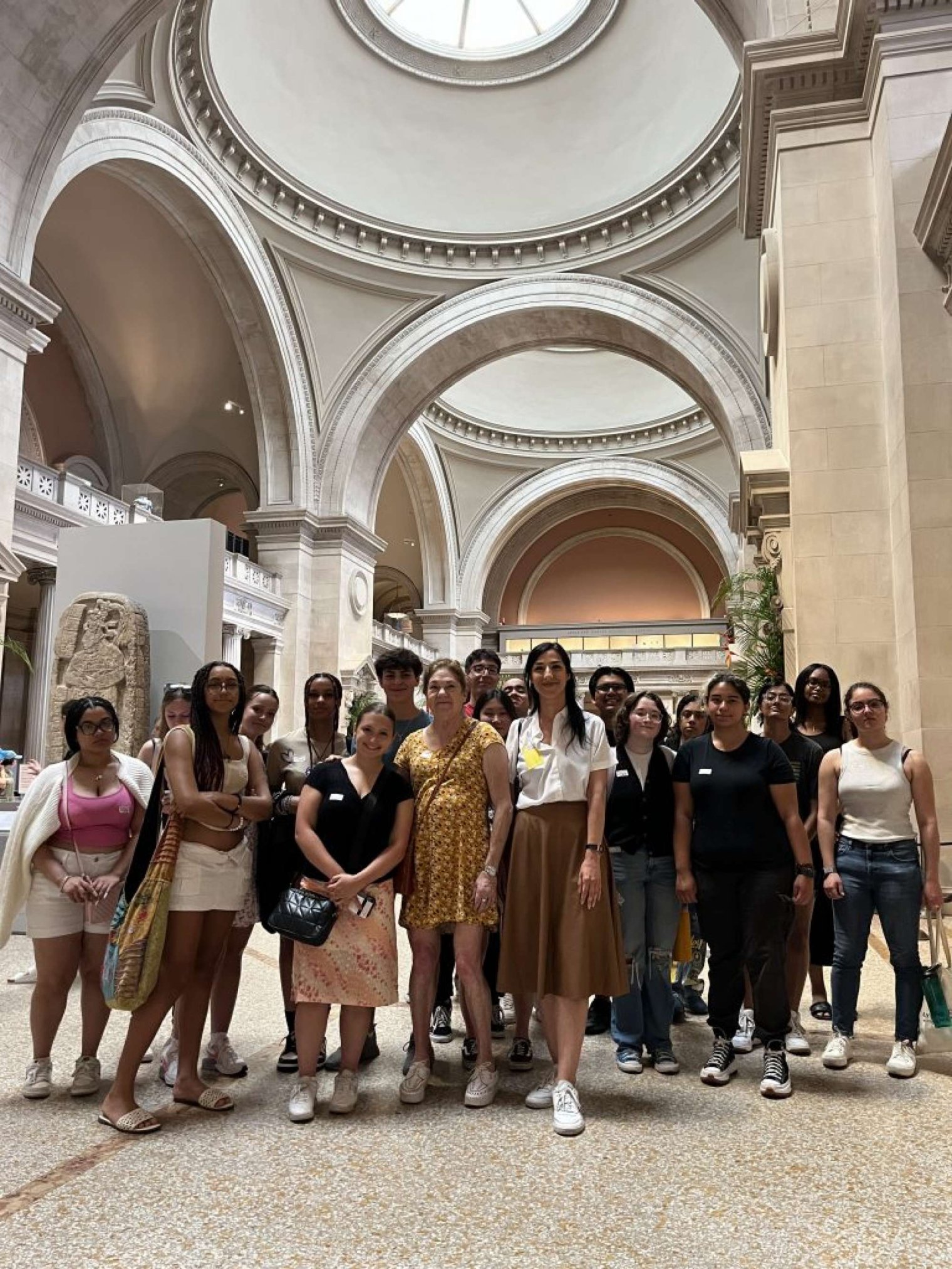 A group of college students pose in an atrium of The Met