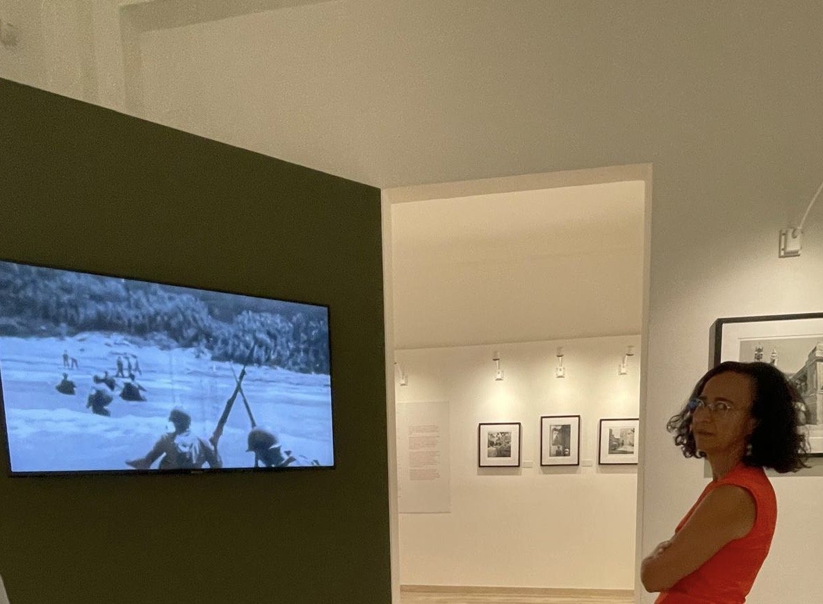 A woman watches a video board inside a museum