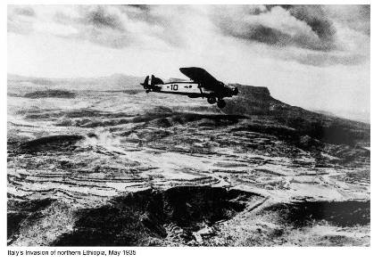 A black and  white photo of an airplane plane flying over a mountainous region