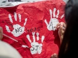 A red Montclair red rock with a white hand on the rock.