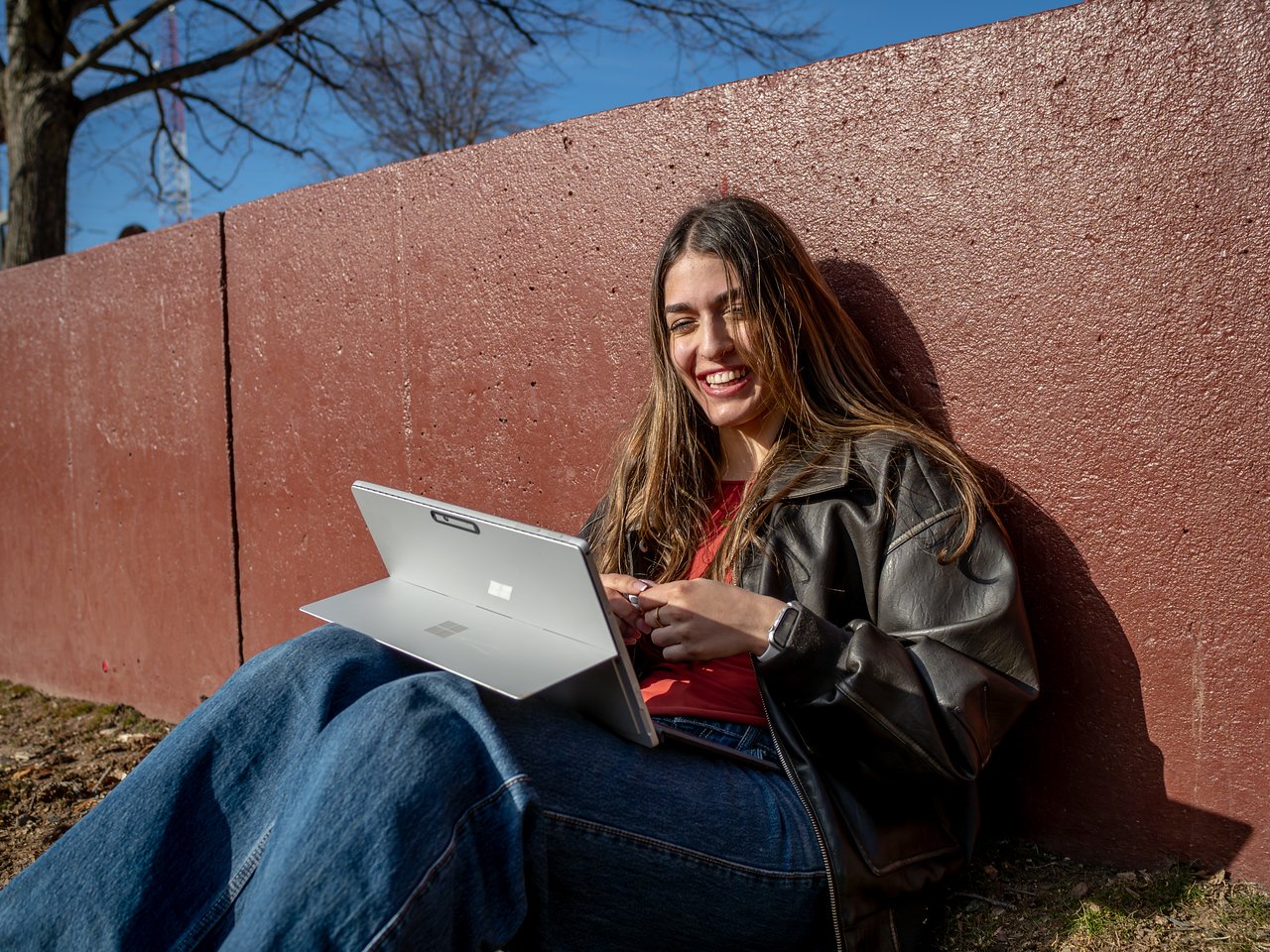 student working on laptop smiling