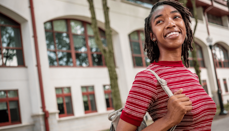 student smiling with backpack