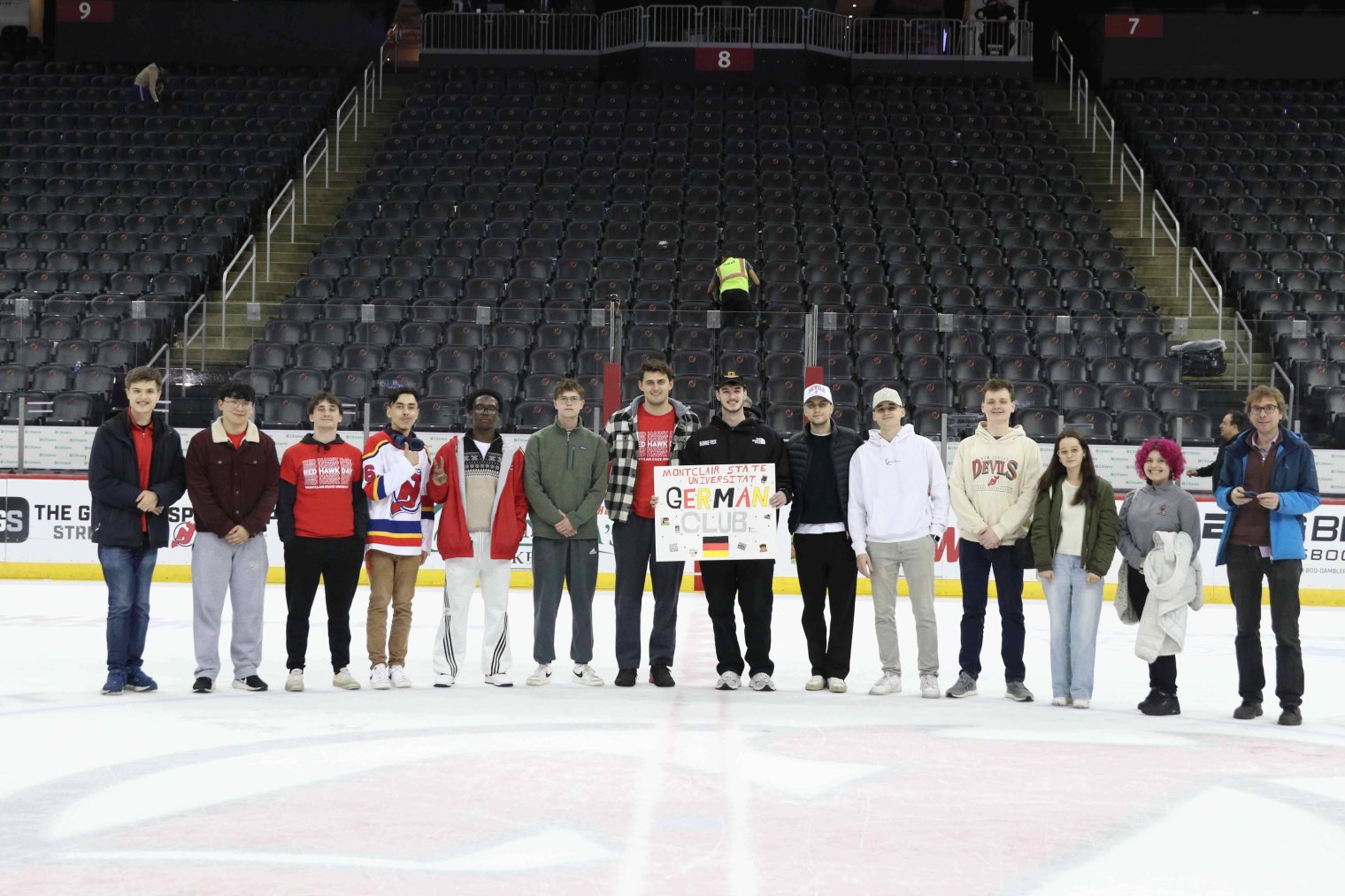 A group of college students pose at center ice at the Prudential Center