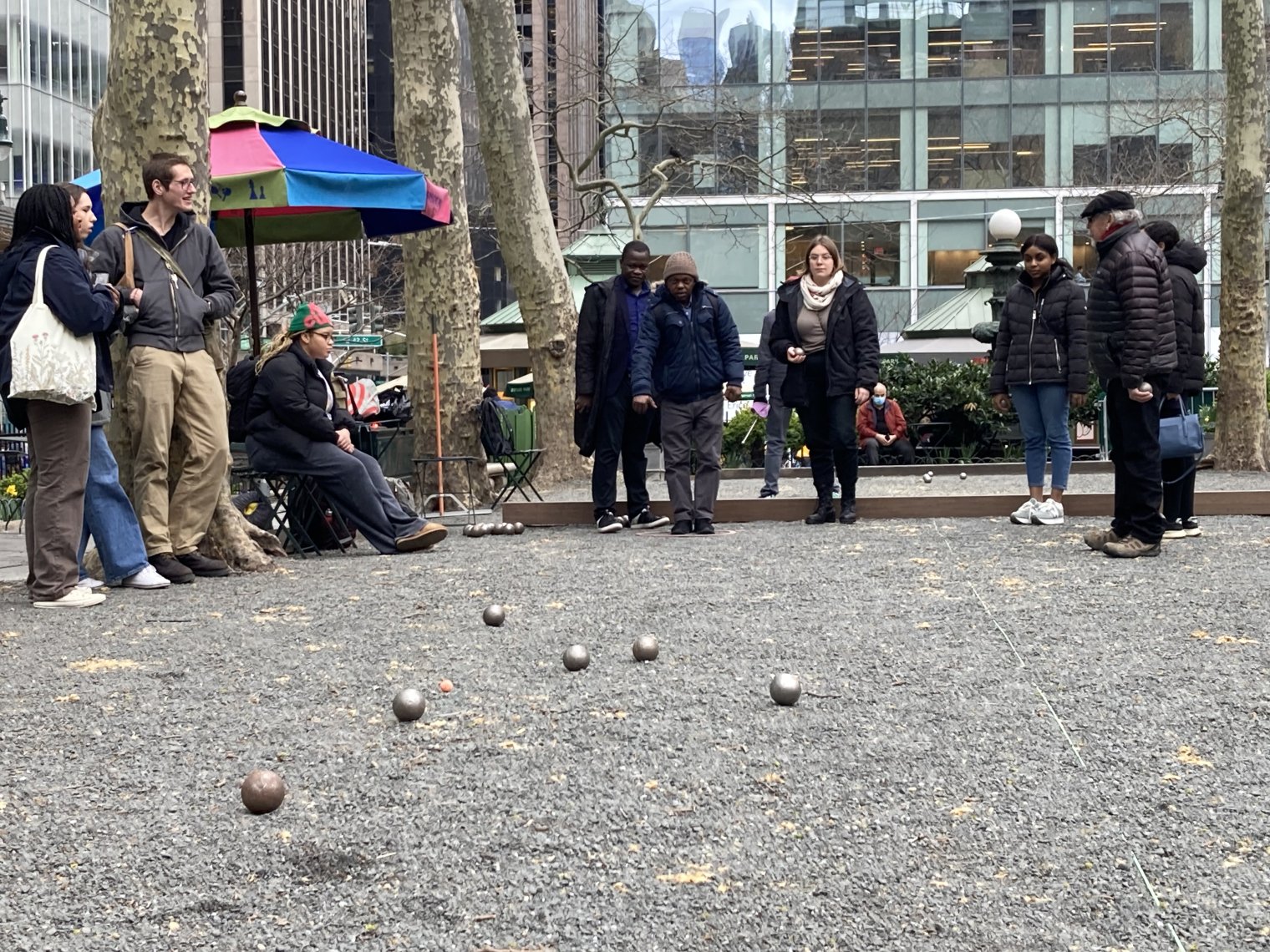 A group of college students play bocce ball in a park