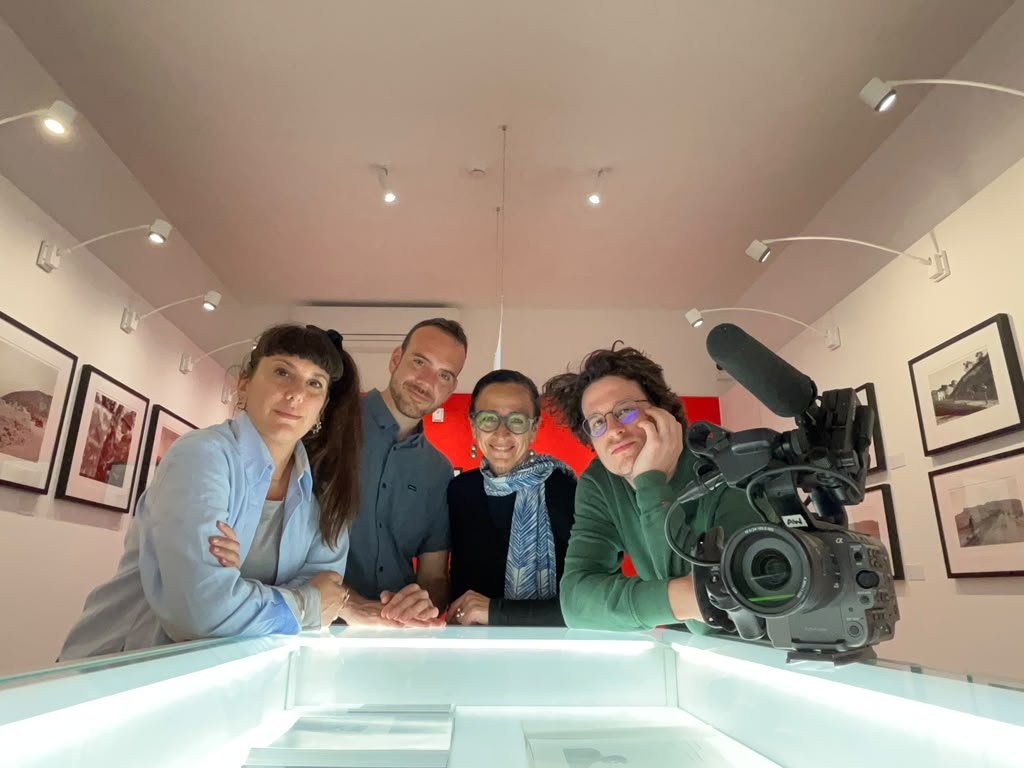 A group of people pose with a camera inside a museum room