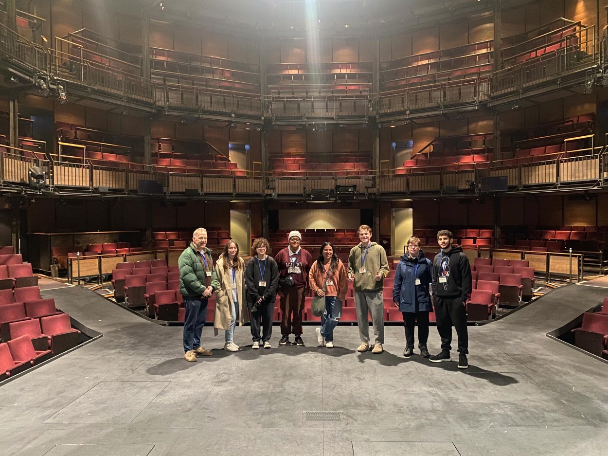 A group of people stand on the stage of the Royal Shakespeare Theatre