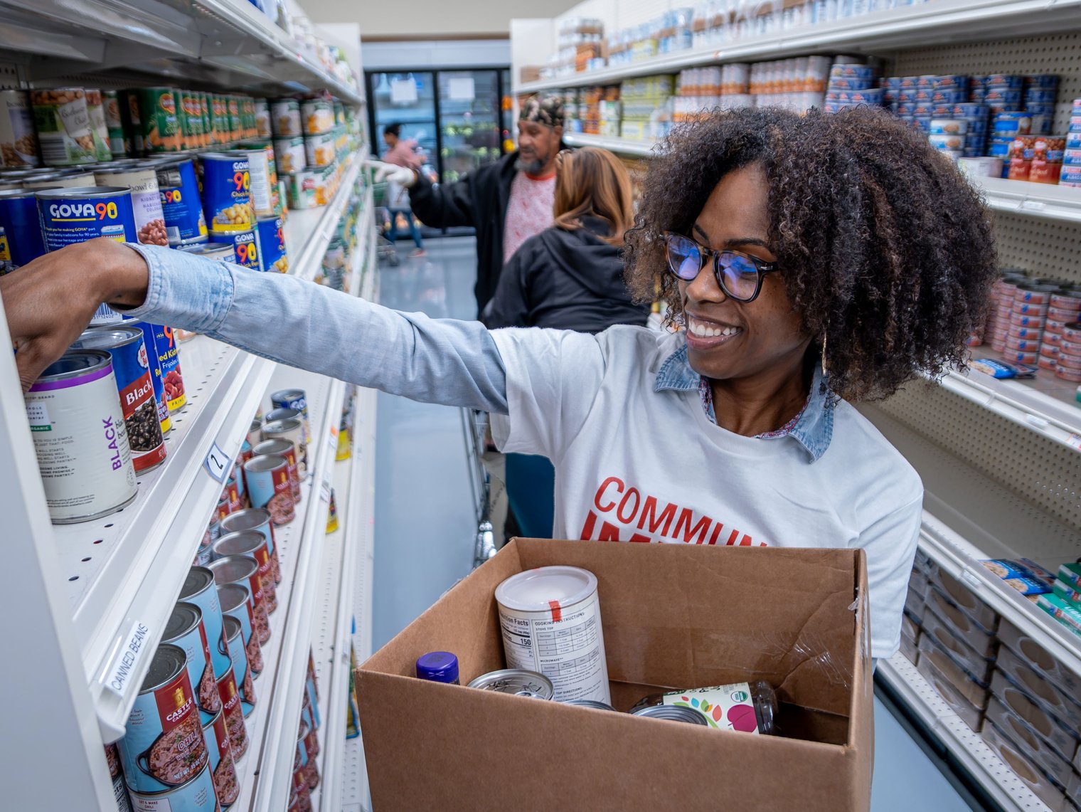 Tabitha Riley stocks grocery shelves at Father English Community Center, which operates a consumer-choice food pantry in Paterson.