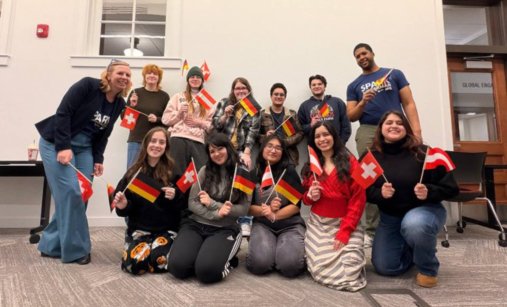 A group of students posing with handheld German, Swiss, and Austrian flags