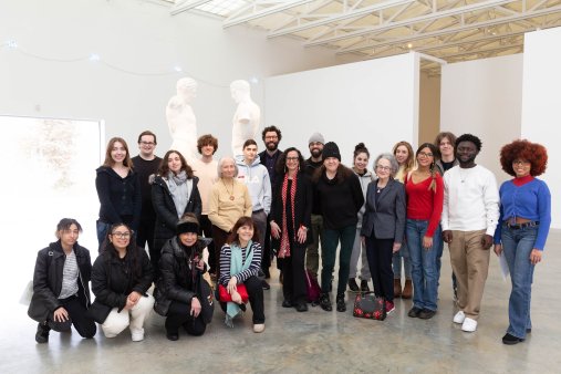A group of people pose in front of sculptures in an art museum