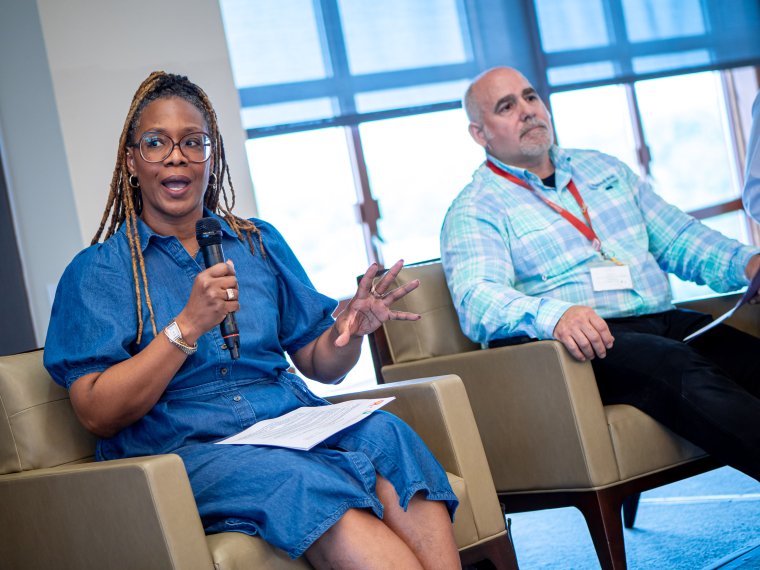 a woman on a panel speaks into a mic