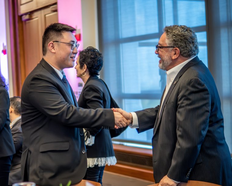 Student shakes hand with board member