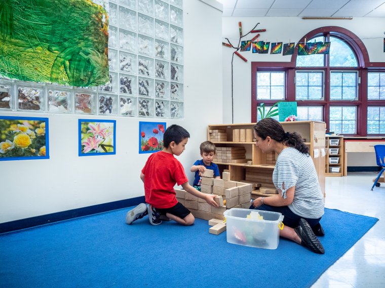 Teacher builds blocks with preschool children