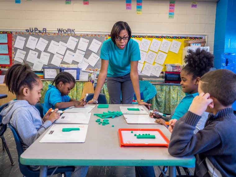 a teacher leads a group of students in a lesson