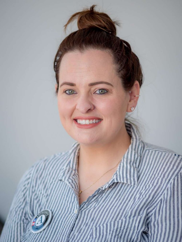 Headshot of Krystal Woolston in Blue and white stripped button up shirt.