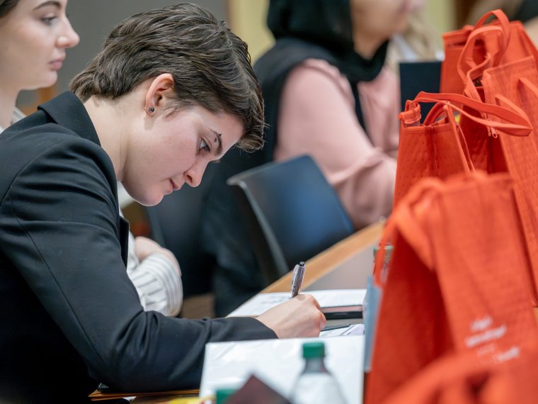 student takes notes at the Educators Exchange career fair