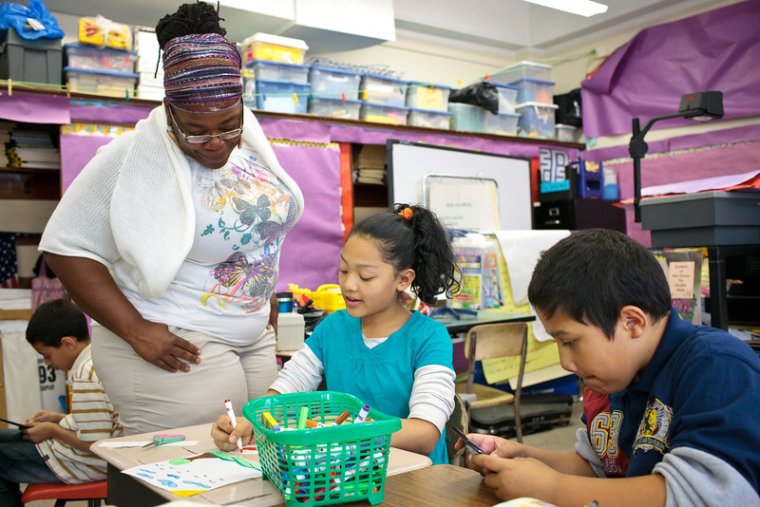 a teacher looks over her student's work