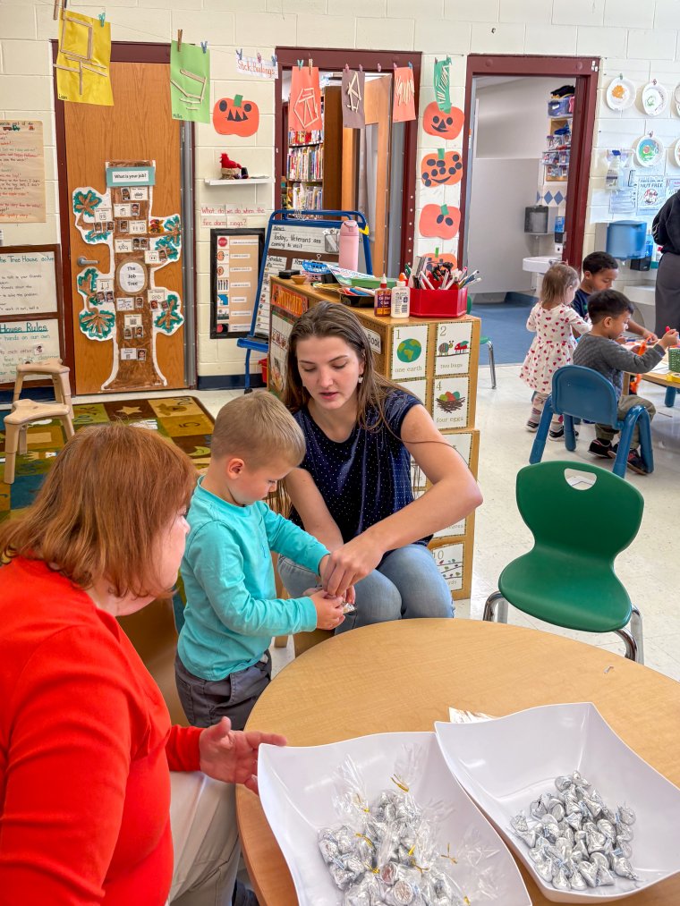 a teacher helps a student with a Veterans Day project