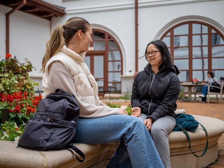 two IAC students chat in the courtyard
