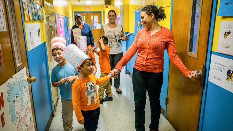 teachers lead kids down hallway