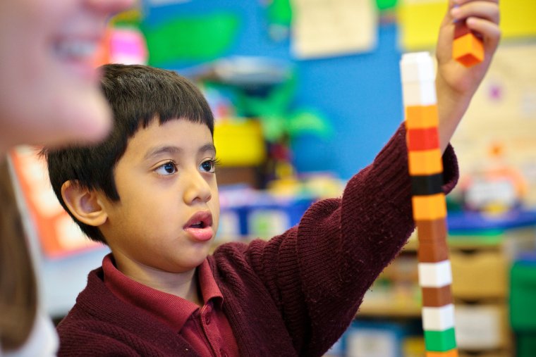 young boy builds with blocks